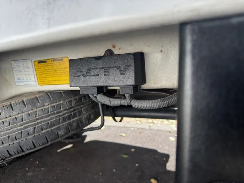 Replacement main fuse cover installed under the bed of a Honda Acty, next to the rear wheel