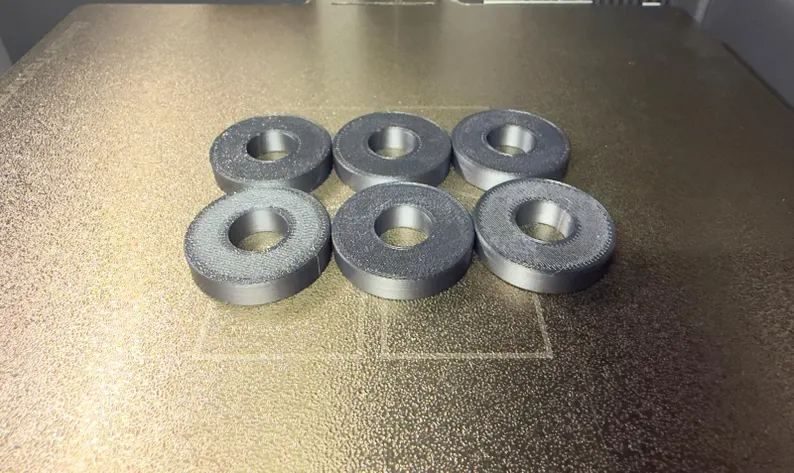 Six solid Honda Acty shifter base bushings on a textured print bed